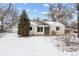 Charming single-story home with an attached garage and a well-maintained front yard, all covered in fresh snow at 7135 W 24Th Ave, Lakewood, CO 80214