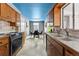 Galley kitchen with oak cabinets, stainless steel appliances, tiled backsplash, and a quaint breakfast nook at the end at 7135 W 24Th Ave, Lakewood, CO 80214