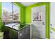 Bright green laundry room featuring a modern washing machine, dryer, and a decorative door at 7135 W 24Th Ave, Lakewood, CO 80214