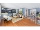 Open-concept living room featuring hardwood floors, modern furniture, and an inviting dining area beyond at 7135 W 24Th Ave, Lakewood, CO 80214