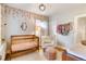 Cozy Bedroom with a wooden crib, accent chair, and floral wallpaper, creating a charming and welcoming space for a baby at 3085 W 36Th Ave, Denver, CO 80211