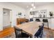 Bright dining room featuring a wooden table, piano, and seamless flow to the kitchen, perfect for modern living and entertaining at 3085 W 36Th Ave, Denver, CO 80211
