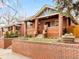 Charming brick home with a cozy covered front porch, landscaped yard, and brick perimeter wall at 3085 W 36Th Ave, Denver, CO 80211