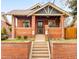 Charming brick home with a covered front porch and manicured landscaping at 3085 W 36Th Ave, Denver, CO 80211