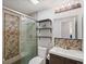 Well-lit bathroom featuring a sleek vanity, patterned tile shower, and modern fixtures at 5873 S Prince St # 209B, Littleton, CO 80120