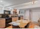 Modern kitchen and dining area featuring black appliances and warm wood cabinetry at 5873 S Prince St # 209B, Littleton, CO 80120