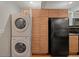 Convenient laundry area with stacked washer and dryer, plus additional storage cabinets at 5873 S Prince St # 209B, Littleton, CO 80120