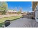 Backyard with a deck, lush green lawn, and a stone retaining wall for added landscape design at 5429 S Waco St, Centennial, CO 80015