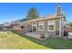 Exterior view of a home showcasing a backyard with a deck, lawn, and mature trees at 5429 S Waco St, Centennial, CO 80015