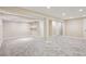 Large basement area with neutral carpet, support beams, and access to other rooms at 5429 S Waco St, Centennial, CO 80015