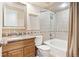 This bathroom features a shower/tub combo with tile surround, a toilet, and a wood vanity with granite countertop at 5429 S Waco St, Centennial, CO 80015