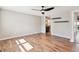 Large bedroom with hardwood floors, a ceiling fan, two floating shelves, and neutral-colored walls at 5429 S Waco St, Centennial, CO 80015