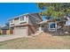 Attractive home boasts brick accents, mature landscaping, and a driveway leading to an attached garage at 5429 S Waco St, Centennial, CO 80015