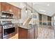 Open kitchen with stainless steel appliances, granite countertops, kitchen island, and vaulted ceilings at 5429 S Waco St, Centennial, CO 80015