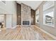 Open living room with hardwood floors, a floor to ceiling stone fireplace, and lots of natural light at 5429 S Waco St, Centennial, CO 80015