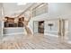 Open-concept living room with stone fireplace, wet bar, hardwood floors, and easy kitchen access at 5429 S Waco St, Centennial, CO 80015
