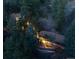 Aerial view of a pair of illuminated homes nestled among dense trees at 9506 S Deer Creek Canyon Rd, Littleton, CO 80127