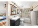 Bathroom featuring tiled shower over tub, a modern vanity, and a well-lit mirror and tile at 9506 S Deer Creek Canyon Rd, Littleton, CO 80127