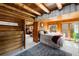 Cozy bedroom with wood-paneled walls, access to an outdoor balcony, and comfortable furnishings at 9506 S Deer Creek Canyon Rd, Littleton, CO 80127