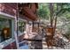 Exterior view of a log cabin with a spacious wooden deck and forest surroundings at 9506 S Deer Creek Canyon Rd, Littleton, CO 80127