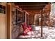 Exterior stone wall with an outdoor seating area and red Adirondack chairs at 9506 S Deer Creek Canyon Rd, Littleton, CO 80127