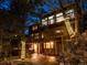 Stunning two-story home featuring a wooden deck, outdoor seating and trees wrapped in string lights at 9506 S Deer Creek Canyon Rd, Littleton, CO 80127