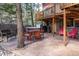 The backyard patio features a hot tub, dining table, chairs, grill and comfortable seating at 9506 S Deer Creek Canyon Rd, Littleton, CO 80127