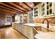 Spacious kitchen boasts stone walls, wooden ceiling, custom cabinets and a farmhouse sink at 9506 S Deer Creek Canyon Rd, Littleton, CO 80127