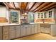 Rustic kitchen features stone walls, wood ceiling, white cabinets, and gas cooktop at 9506 S Deer Creek Canyon Rd, Littleton, CO 80127