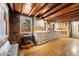 Charming kitchen featuring wooden ceilings, stone walls, wood floors, and rustic cabinets at 9506 S Deer Creek Canyon Rd, Littleton, CO 80127