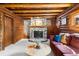 Charming living room with log walls, stone fireplace, and comfortable seating at 9506 S Deer Creek Canyon Rd, Littleton, CO 80127