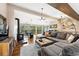 Open-concept living area with wood floors, fireplace, and beautiful outdoor views from large windows at 9506 S Deer Creek Canyon Rd, Littleton, CO 80127