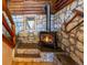 Rustic staircase with stone walls, wood ceilings, stone steps, and a cozy fireplace at 9506 S Deer Creek Canyon Rd, Littleton, CO 80127
