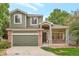 Charming two-story home with a well-maintained lawn, complemented by a brick facade and a covered front porch at 13612 Plaster Cir, Broomfield, CO 80023