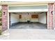 Open garage view displaying storage cabinets and entrance with brick and siding trim at 13612 Plaster Cir, Broomfield, CO 80023
