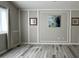 A spacious living room featuring wall trim, neutral paint, and grey wood floors at 13612 Plaster Cir, Broomfield, CO 80023