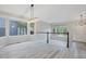 Bright living room featuring stylish gray flooring, complemented by large windows and modern lighting fixtures at 13612 Plaster Cir, Broomfield, CO 80023