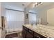 Bathroom with granite countertop vanity, framed mirror, overhead lights, shower and bath with black and white curtain at 5420 Allison St # 202, Arvada, CO 80002
