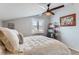 Bedroom features a ceiling fan, neutral walls, natural light, book shelf, and a comfortably made bed at 5420 Allison St # 202, Arvada, CO 80002