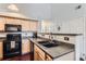 Functional kitchen with black appliances, light wood cabinetry, and a modern sink at 5420 Allison St # 202, Arvada, CO 80002
