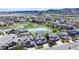 Aerial view of a neighborhood with a pond, park, and houses with mountain backdrop at 9804 N Crystal Lake Dr, Littleton, CO 80125