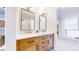 Bathroom featuring dual sinks, a marble countertop, rectangular mirrors and modern fixtures at 9804 N Crystal Lake Dr, Littleton, CO 80125
