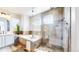 This bathroom showcases a glass-enclosed shower, soaking tub with tile surround and neutral color palette at 9804 N Crystal Lake Dr, Littleton, CO 80125
