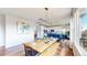 Bright, open-concept dining room next to a modern kitchen with hardwood floors and a long dining table at 9804 N Crystal Lake Dr, Littleton, CO 80125