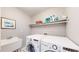 Laundry room with washer, dryer, utility sink and shelf space at 9804 N Crystal Lake Dr, Littleton, CO 80125