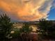 Scenic view of a neighborhood featuring a pond, houses, and a vibrant sunset sky at 9804 N Crystal Lake Dr, Littleton, CO 80125