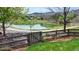 Scenic pond view featuring a charming wooden gate and tranquil walking path at 9804 N Crystal Lake Dr, Littleton, CO 80125