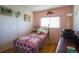 Cozy bedroom with pink walls, window, and a comfortable-looking twin-sized bed with decorative linens at 2296 E 109Th Dr, Northglenn, CO 80233