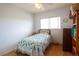 Well-lit bedroom featuring wood flooring, a window, ceiling fan, and a neatly made twin bed at 2296 E 109Th Dr, Northglenn, CO 80233