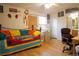 Bedroom with a bed featuring vibrant colors, wood floor, window, office chair, and attached bathroom at 2296 E 109Th Dr, Northglenn, CO 80233